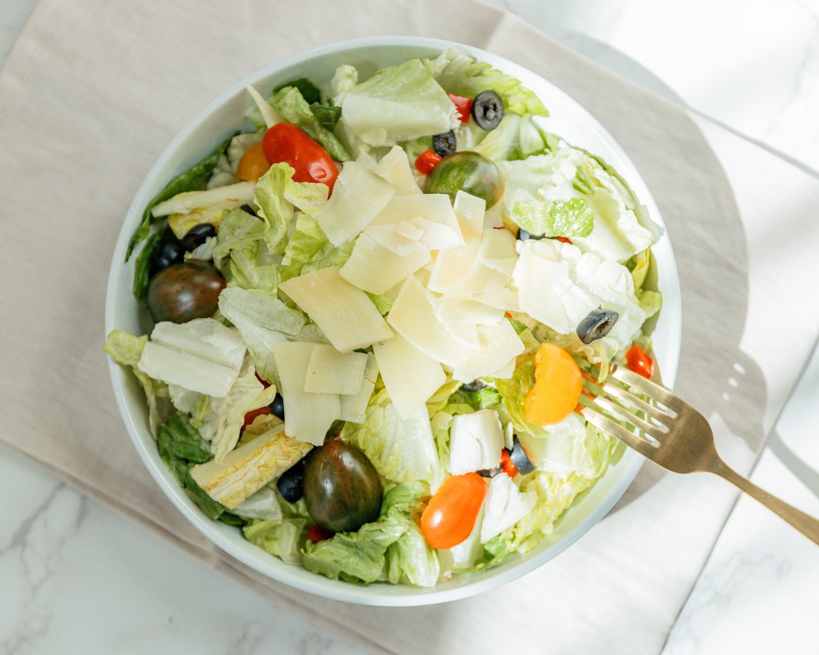 Italian salad with chopped romaine, shaved parmesan, olives, cherry tomatoes, and peppers