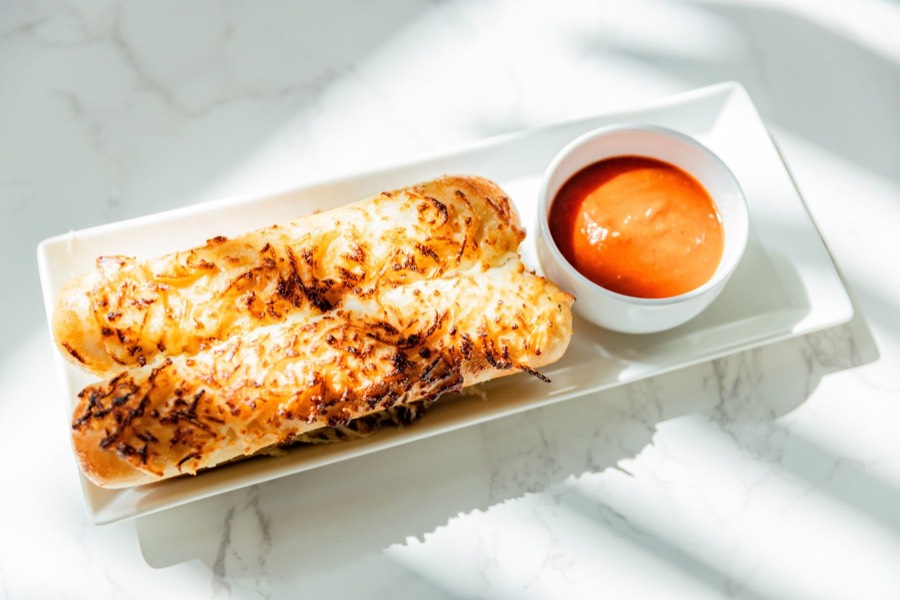 Cheesy Garlic Bread Sticks — garlic bread sticks topped with melted cheese, served with marinara